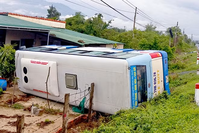 Sau khi đảo hướng lái lao xuống lề, chiếc xe buýt lật nghiêng trong sân nhà dân. Ảnh : CTV
