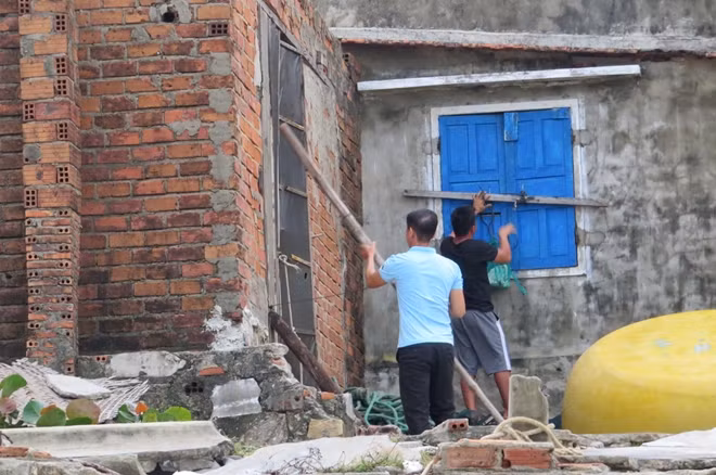 Người dân cài, chắn cửa sổ, cửa chính không để gió bão luồn vào bên trong cuốn tốc mái nhà. Ảnh : Đào Tuấn