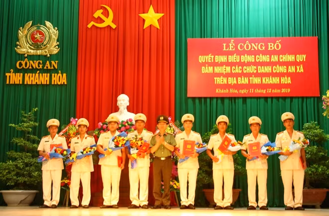 Đại tá Hoàng Văn Toàn, Phó Cục trưởng Cục Xây dựng phong trào bảo vệ an ninh Tổ quốc tặng hoa, chúc mừng cán bộ công an chính quy đảm nhiệm chức danh công an xã. Ảnh: Hữu Toàn