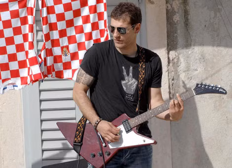 HLV Bilic chơi guitar trong ban nhạc Rawbau.