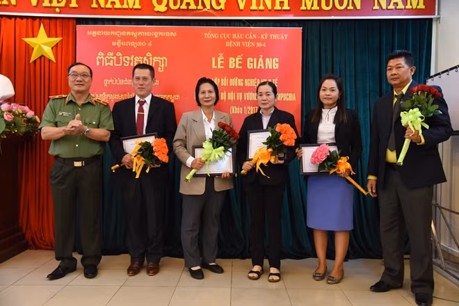 Thiếu tướng Tống Mạnh Chinh trao chứng nhận vào tặng hoa cho đoàn công tác.