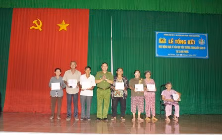 Trung tá Trần Văn Tuấn, Phó Hiệu trưởng đại diện cho Nhà trường lên trao các suất quà cho bà con diện chính sách.