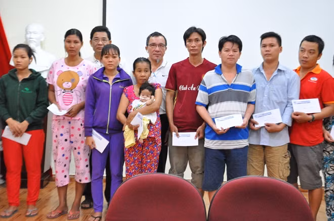 Ông Lâm Tấn Lợi, Giám đốc Công ty Sản xuất Duy Lợi trao quà cho gia đình các bệnh nhân.
