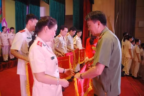 Trung tướng Trần Bá Thiều, Tổng cục trưởng Tổng cục Chính trị CAND trao cờ lưu niệm tặng đội thi Báo Công an nhân dân.