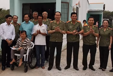 Đồng chí Bộ trưởng cùng các thành viên trong đoàn và vợ chồng anh Dũng trước căn nhà tình nghĩa.