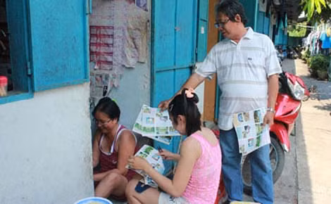 Ông Ba Định phát tờ rơi tuyên truyền sức khoẻ sinh sản cho công nhân.