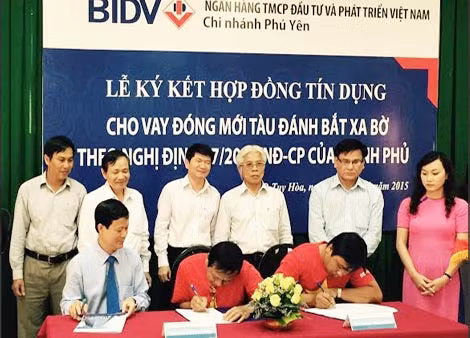 Hai ngư dân ký hợp đồng vay vốn với BIDV.
