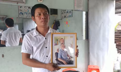 Anh thợ cắt tóc Nguyễn Thanh Phong cùng bức ảnh chụp chung với cố Thủ tướng Phan Văn Khải.