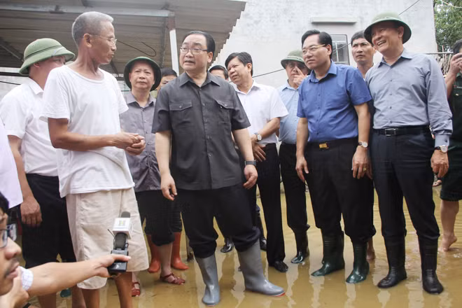 Bí thư Thành ủy Hà Nội Hoàng Trung Hải thăm, động viên các hộ dân đang bị ngập lụt tại xã Nam Phương Tiến (huyện Chương Mỹ). Ảnh: TTXVN.