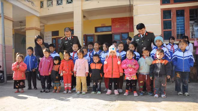 Thượng tá Trần Duy Hiển, Trưởng ban Pháp luật – Bạn đọc cùng bà Trần Thị Thúy Nga, đại diện Văn Phú – Invest; đại diện Công an tỉnh Lai Châu thăm hỏi các em học sinh ở xã Trung Đồng đến nhận quà Tết.