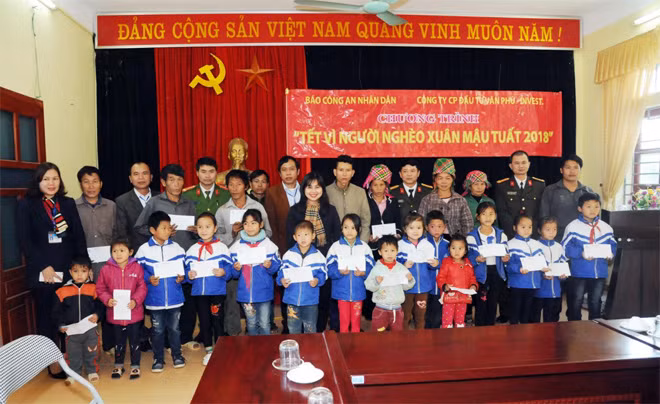 Các em học sinh nghèo hiếu học và bà con xã Trung Đồng nhận quà từ Chương trình “Tết vì người nghèo”.
