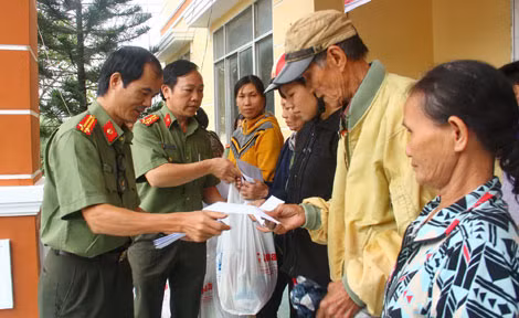 Thượng tá Đặng Ngọc Như và Trung tá Nguyễn Đức Vinh - Phó trưởng Cơ quan đại diện Báo CAND trao tặng quà tết cho người dân ở xã Xuân Phước, Xuân Lãnh.