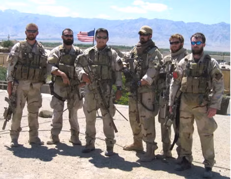 Trung sĩ Marcus Luttrell (đứng giữa - trước lá cờ) cùng nhóm SEAL 10 trước lúc lên trực thăng nhảy xuống sườn núi Sawtalo Sar.