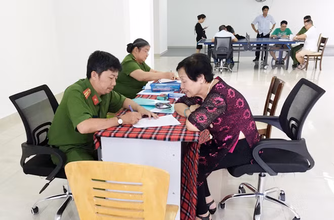 Công an phường cấp sổ tạm trú cho người dân ở chung cư.