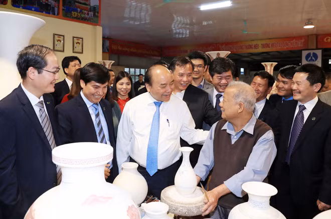 Thủ tướng Nguyễn Xuân Phúc thăm hỏi người lao động tại Công ty cổ phần Gốm Chu Đậu. Ảnh: TTXVN.