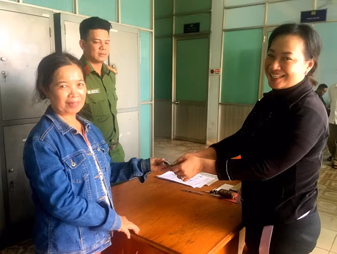 Bà Nguyễn Thị Tảo (bên trái) trao số tiền nhặt được cho chị Hậu tại trụ sở Công an phường Lạc Đạo, TP Phan Thiết, Bình Thuận.
