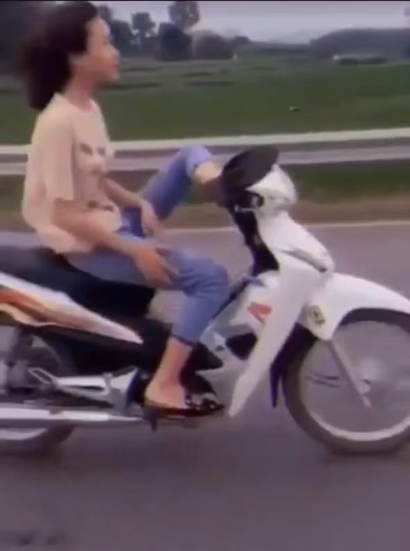 Hình ảnh A.T.H bỏ tay, điều khiển xe máy bằng chân đăng trên mạng xã hội