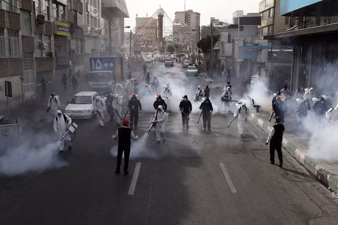 Phun thuốc khử trùng trên đường phố Tehran. Ảnh AP.