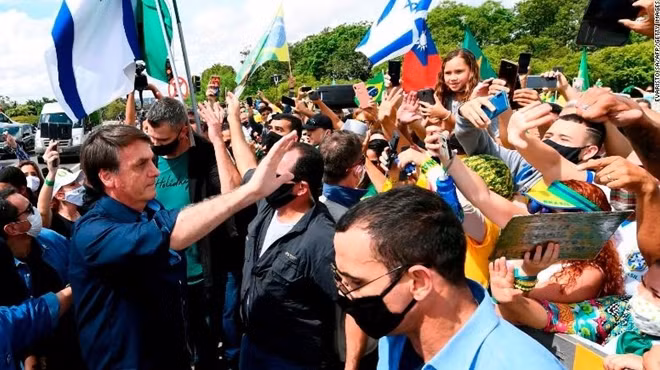 Tổng thống Jair Bolsonaro gặp người ủng hộ nhưng không đeo khẩu trang. Ảnh Getty Images.