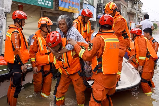 Lính cứu hỏa của Trung Quốc cứu hộ những người bị mắc kẹt do lũ. Ảnh SCMP.