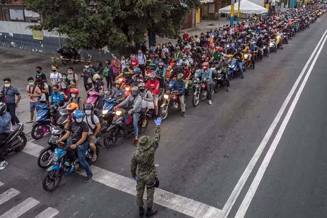 Người đi xe máy xếp hàng tại một điểm kiểm tra y tế tại Manila. Ảnh Getty Images.