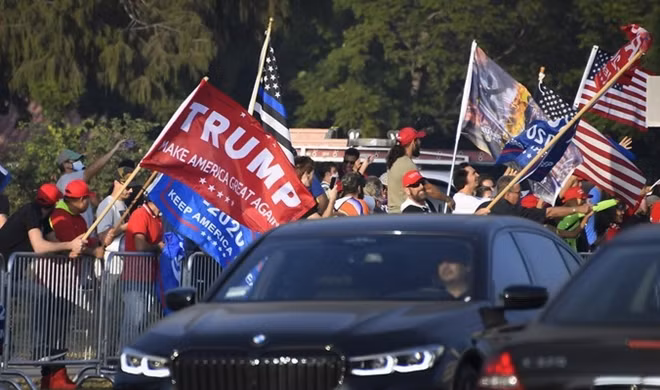 Người ủng hộ vẫy quốc kỳ Mỹ và thông điệp tranh cử của Trump tại bang California ngày 3/11. Ảnh: Reuters.