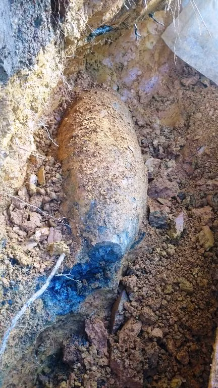Máy xúc đào sứt một góc quả bom Máy xúc đào sứt một góc quả bom