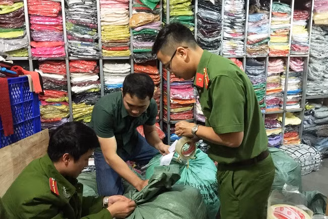 Lực lượng Công an đang thu giữ sản phẩm áo len không rõ nguồn gốc tại cửa hàng của bà Nguyễn Thị Ngọc Hải Lực lượng Công an đang thu giữ sản phẩm áo len không rõ nguồn gốc tại cửa hàng của bà Nguyễn Thị Ngọc Hải