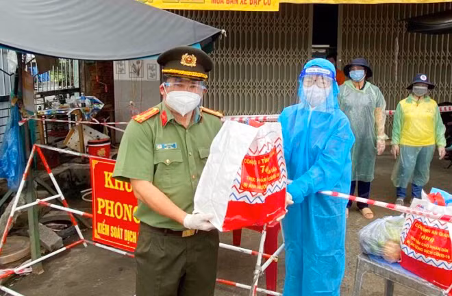 Giám đốc Công an tỉnh An Giang trao quà cho Tổ công tác liên ngành tại khu vực phong tỏa phường Mỹ Thời, TP Long Xuyên, để phát cho các hộ dân.