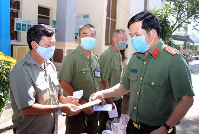 Đại tá Đinh Văn Nơi trao quà Tết cho lực lượng BVDP và người dân khó khăn.