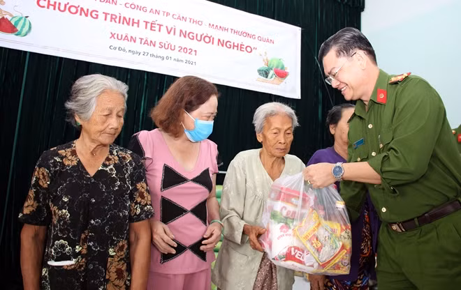 Thượng tá Nguyễn Văn Quốc, Trưởng Công an huyện Cờ Đỏ trao quà cho người dân.