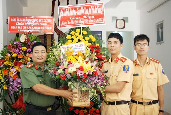 Đại diện Ban Chỉ huy Thủy đoàn II (Cục CSGT) tặng hoa, chúc mừng Báo CAND – Văn phòng thường trú tại ĐBSCL.