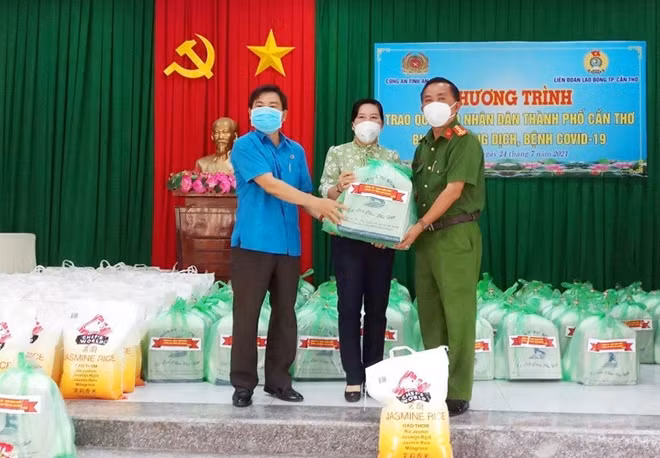 Đại tá Bùi Bé Năm, Phó Giám đốc Công an tỉnh An Giang bàn giao những phần quà cho lãnh đạo huyện Phong Điền (TP Cần Thơ) để chuyển đến các khu cách ly tập trung.