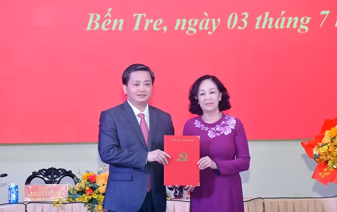 Đồng chí Trương Thị Mai trao Quyết định của Bộ Chính trị cho đồng chí Lê Đức Thọ.