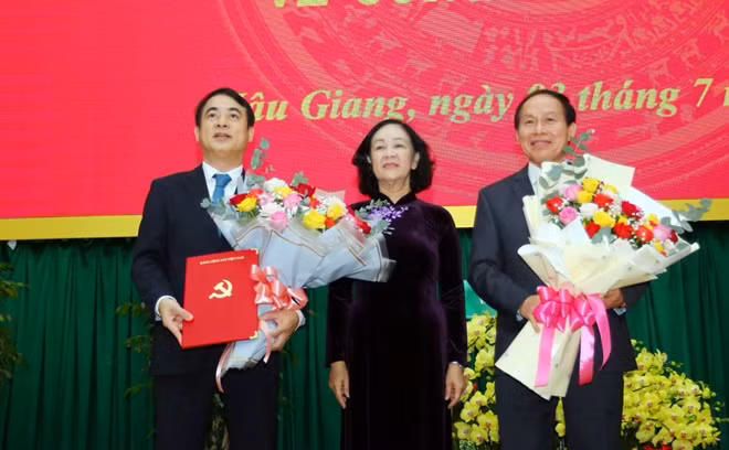 Đồng chí Trương Thị Mai chúc mừng đồng chí Nghiêm Xuân Thành (bìa trái) và đồng chí Lê Tiến Châu (bìa phải) nhận nhiệm vụ mới.