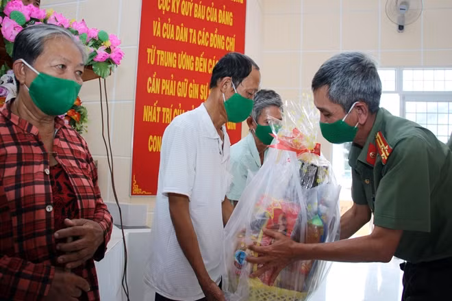 Thượng tá Nguyễn Văn Phục, Trưởng phòng An ninh điều tra Công an tỉnh Vĩnh Long tặng quà cho người dân khó khăn trên cù lao Phú Thành.