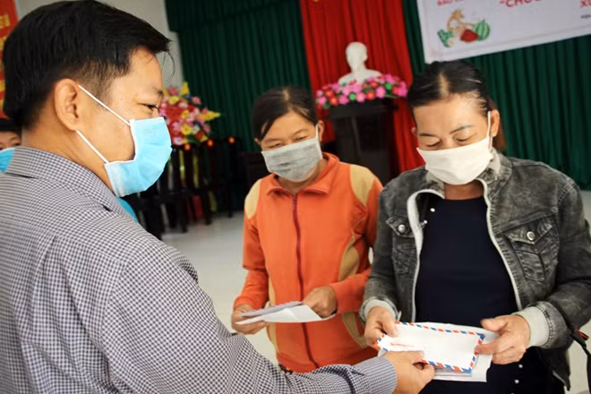 Đại diện chính quyền địa phương trao quà cho người dân.