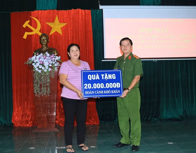 Trung tá Nguyễn Đức Hậu, Trưởng Công an TP Long Xuyên trao bảng tượng trưng số tiền 20 triệu đồng hỗ trợ nhân viên lao động hợp đồng Công an thành phố sửa chữa lại nhà ở.