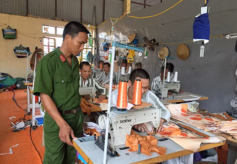 Cán bộ quản giáo Trại giam Nam Hà hướng dẫn phạm nhân lao động tại phân xưởng may.
