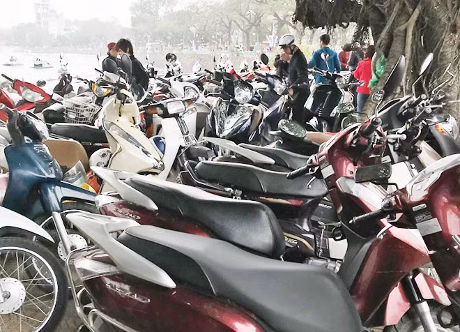 Các điểm trông giữ xe máy ven hồ Trúc Bạch thu mức 10.000 đồng/lượt.