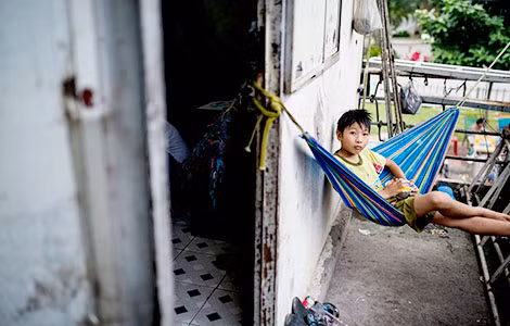 Em bé bị liệt suốt ngày ngồi trên võng.