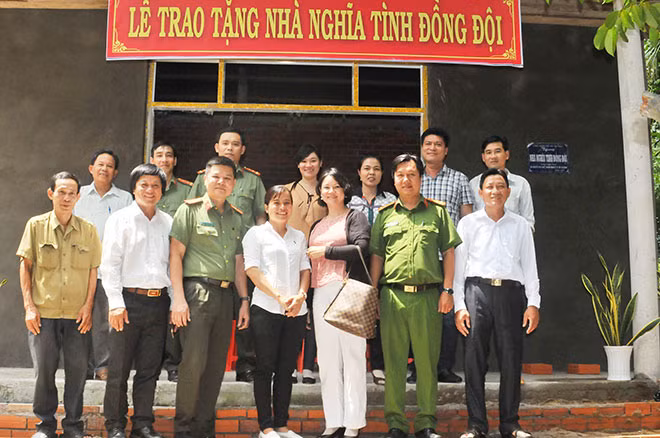 Đoàn công tác và chính quyền địa phương cùng bà con mừng Đại uý Mai Thị Dứt có ngôi nhà mới.