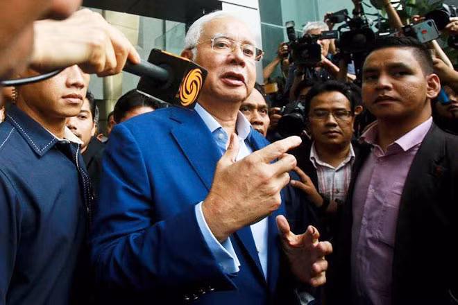 Cựu Thủ tướng Najib Razak trong vòng vây báo giới khi đến trụ sở MACC để trả lời thẩm vấn. Ảnh: Reuters.
