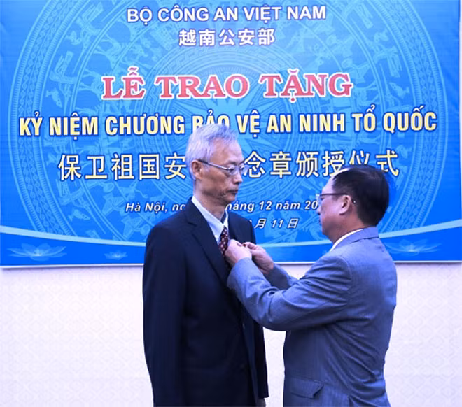 Thứ trưởng Nguyễn Văn Thành gắn Kỷ niệm chương tặng đồng chí Uông Tế Châu.