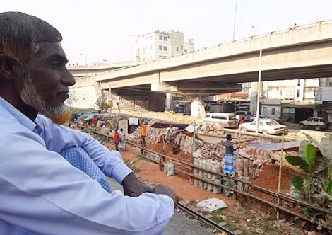 Người đàn ông ngồi trên nóc tàu hỏa đi xuyên Dhaka.
