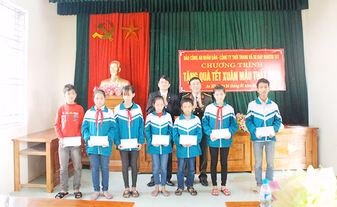 Đại diện Báo CAND và UBND xã An Mỹ trao quà Tết do Công ty thời trang và xe đạp Martin 107 tài trợ cho các học sinh nghèo hiếu học.