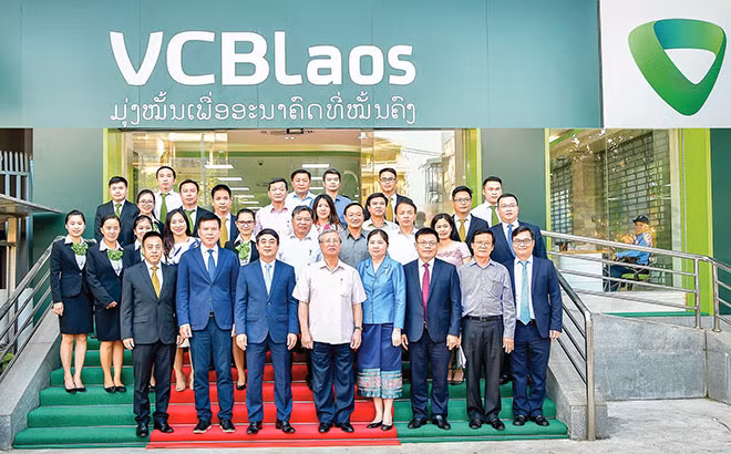 Đồng chí Trần Quốc Vượng, Ủy viên Bộ Chính trị, Thường trực Ban Bí thư (thứ 4 hàng đầu từ trái sang), với Đại diện lãnh đạo Vietcombank, Ban giám đốc và cán bộ nhân viên Vietcombank Lào tại Viên Chăn.