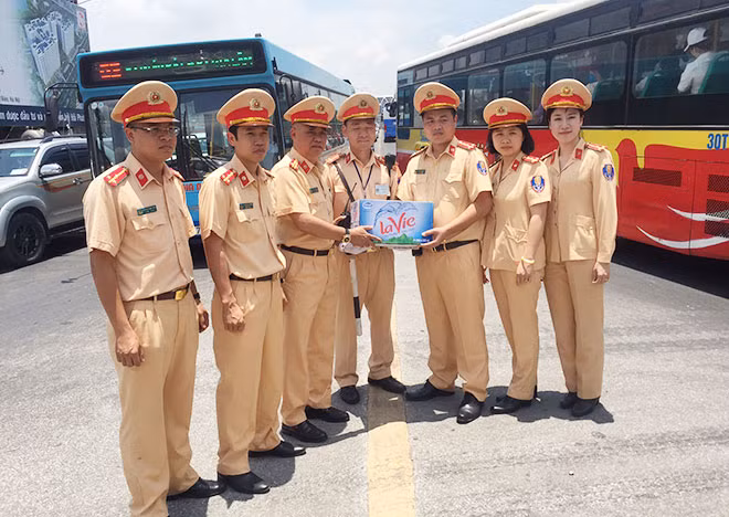 Đại tá Đào Vịnh Thắng động viên và tặng nước cho cán bộ, chiến sỹ CSGT làm nhiệm vụ trong nắng nóng.