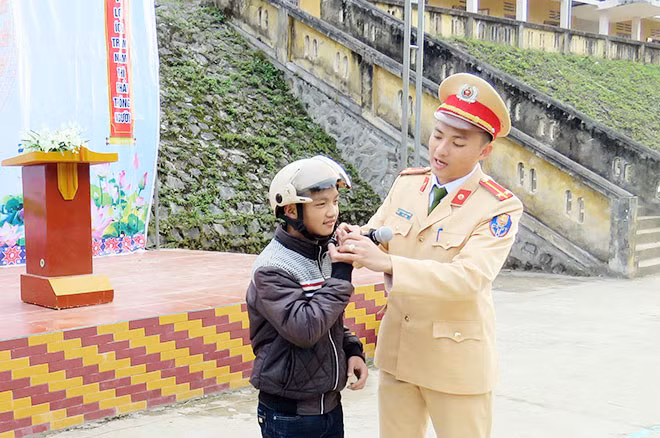 Đội CSGT Công an huyện Bảo Lạc hướng dẫn cách sử dụng mũ bảo hiểm cho các em học sinh trên địa bàn.