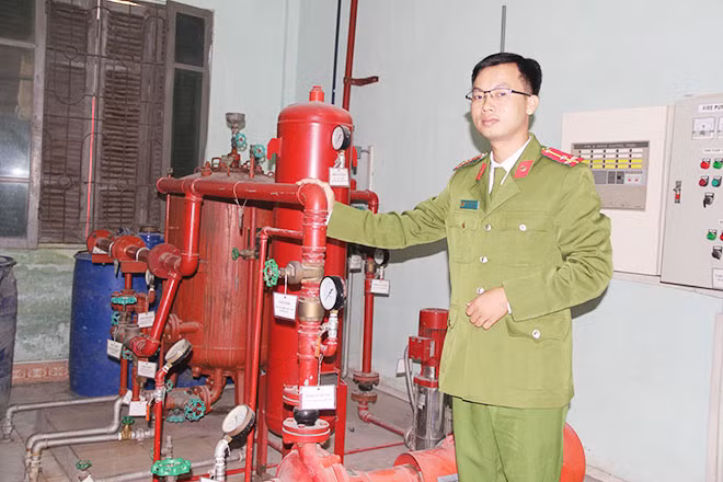 Thượng úy Phạm Văn Thành với các phương tiện kỹ thuật trong phòng thí nghiệm của Khoa Tự động và Phương tiện kỹ thuật PCCC.